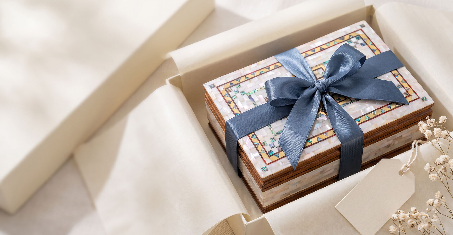 A mother-of-pearl box tied with a blue ribbon